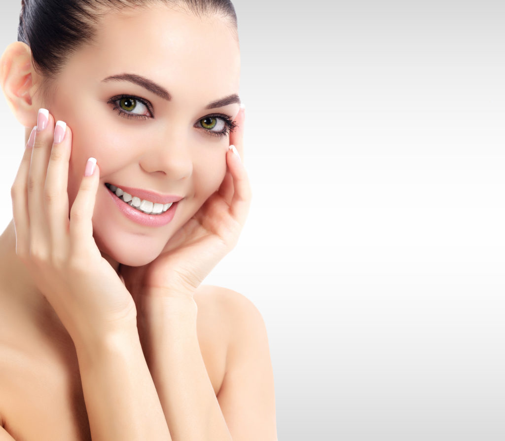 Pretty woman against a grey background with copyspace.